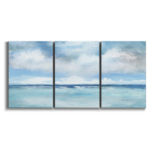 Three-panel canvas wall art featuring tropical clouds over ocean horizon on white background.