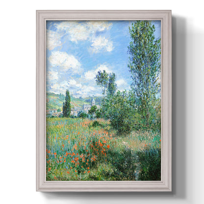 Impressionist pastoral landscape with poppy fields by Claude Monet printed on canvas in an ornate weathered white frame with a vertical orientation.