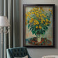 Impressionist floral painting of artichoke flowers by Claude Monet in an ornate black frame with gilded inner detail displayed in a neutral interior setting.