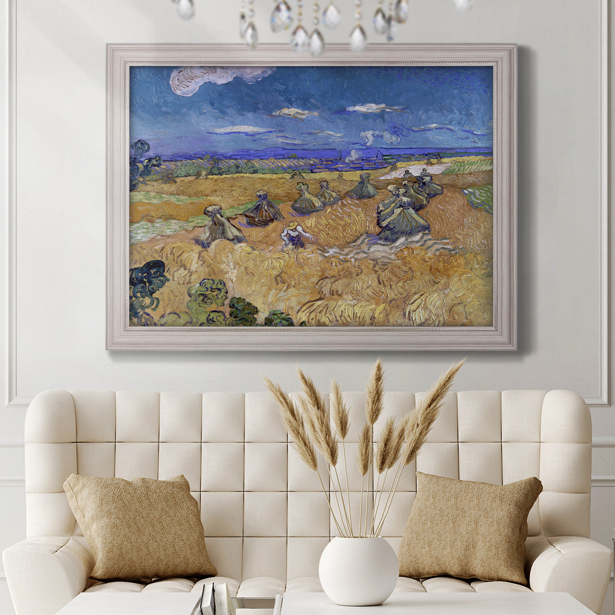 Impressionist wheat harvest scene by Vincent van Gogh in an ornate weathered white frame displayed in a neutral-toned interior setting.