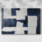 Abstract artwork featuring a contrast of navy blue and white shapes on canvas