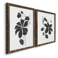 Angled view of a set of two walnut barnwood framed canvas prints featuring two minimalist botanical prints featuring black leafy vine silhouettes.