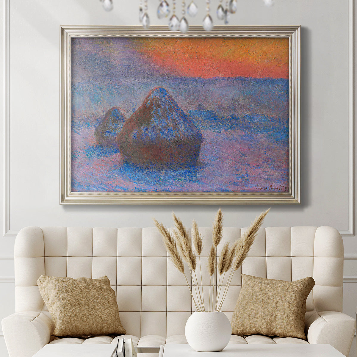 Impressionist haystack scene at sunset by Claude Monet in an ornate champagne frame displayed in a neutral-toned interior setting.