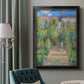 Impressionist garden landscape painting by Claude Monet in an ornate black frame with gilded inner detail displayed in a neutral interior setting.