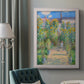 Impressionist garden landscape painting by Claude Monet in an ornate weathered white frame displayed in a neutral interior setting.