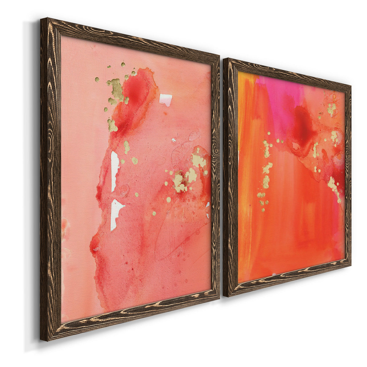 Angled view of a set of two walnut barnwood framed canvas prints featuring two glamorous fluid abstracts featuring luminous coral orange and pink color fields with gold flecks.