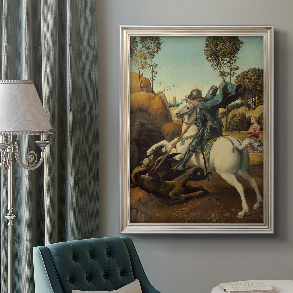 Religious painting of Saint George slaying the dragon by Raphael in an ornate champagne frame displayed in a neutral interior setting.