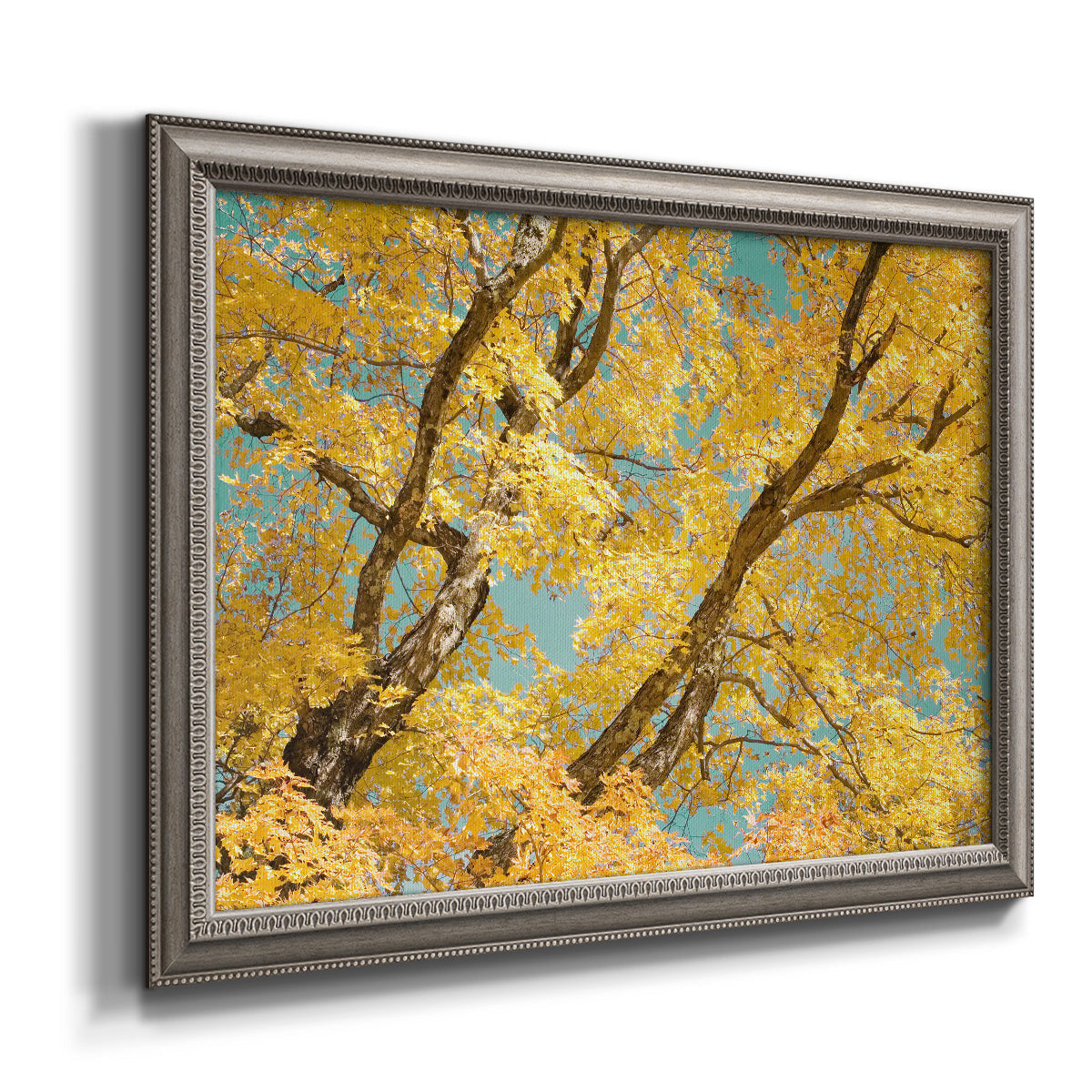 Vibrant yellow autumn leaves on branches printed on canvas in an ornate vintage silver frame.