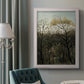 Dreamlike forest landscape scene by Henri Rousseau in an ornate weathered white frame displayed in a neutral interior setting.
