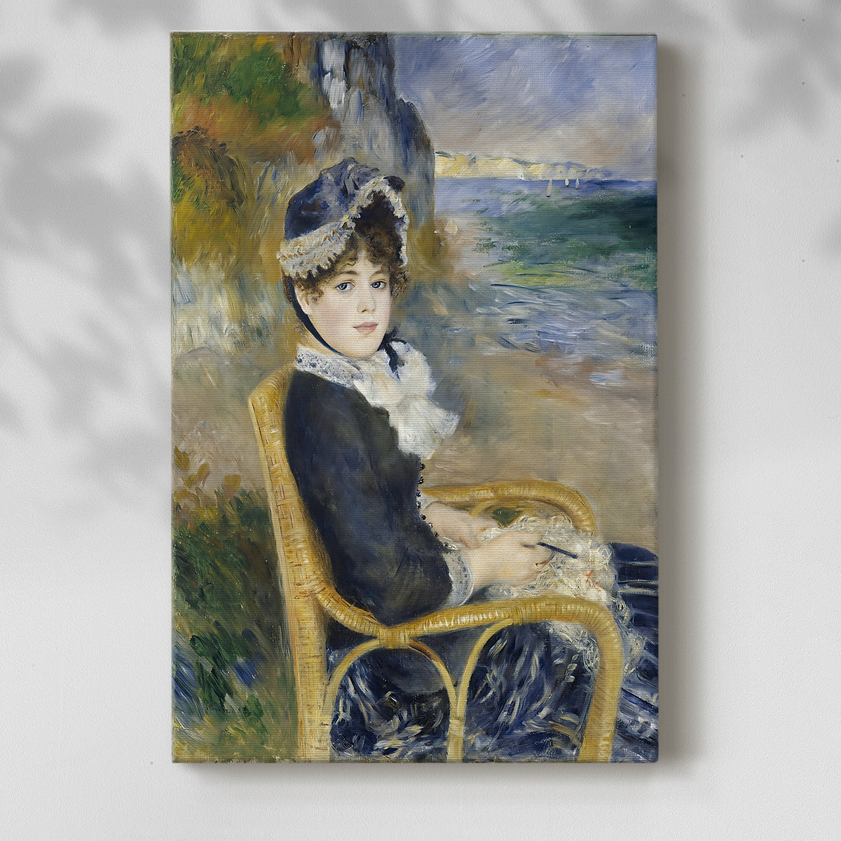 Canvas art print of a coastal scene with a seated figure and flowing garments with a soft shadow on a white background.