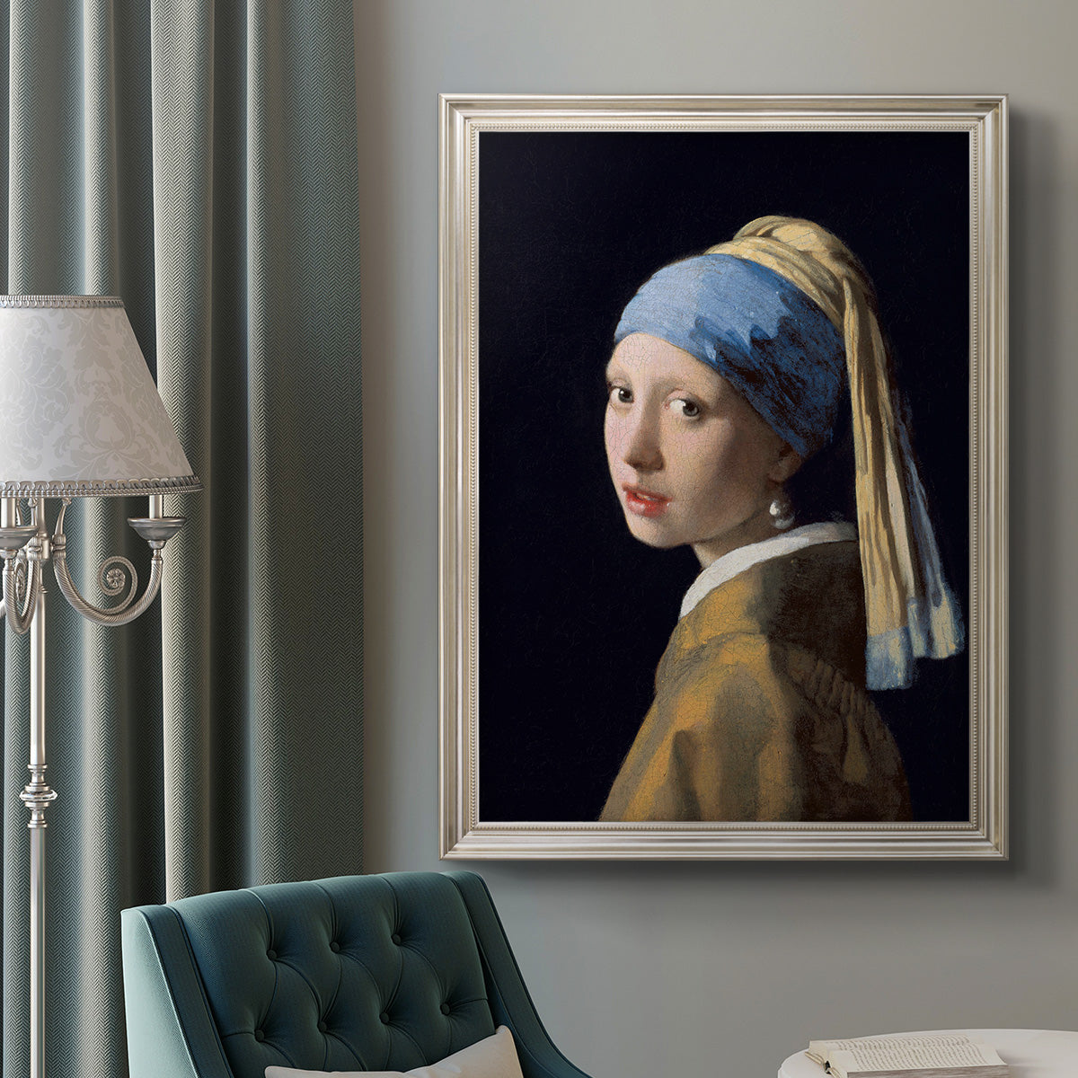 Iconic portrait of a girl wearing a pearl earring by Johannes Vermeer in an ornate champagne frame displayed in a neutral interior setting.