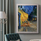 Impressionist night café street scene by Vincent van Gogh in an ornate weathered white frame displayed in a neutral interior setting.