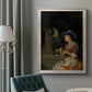 Classical interior scene of a woman weaving flowers by Godfried Schalcken in an ornate champagne frame displayed in a neutral interior setting.