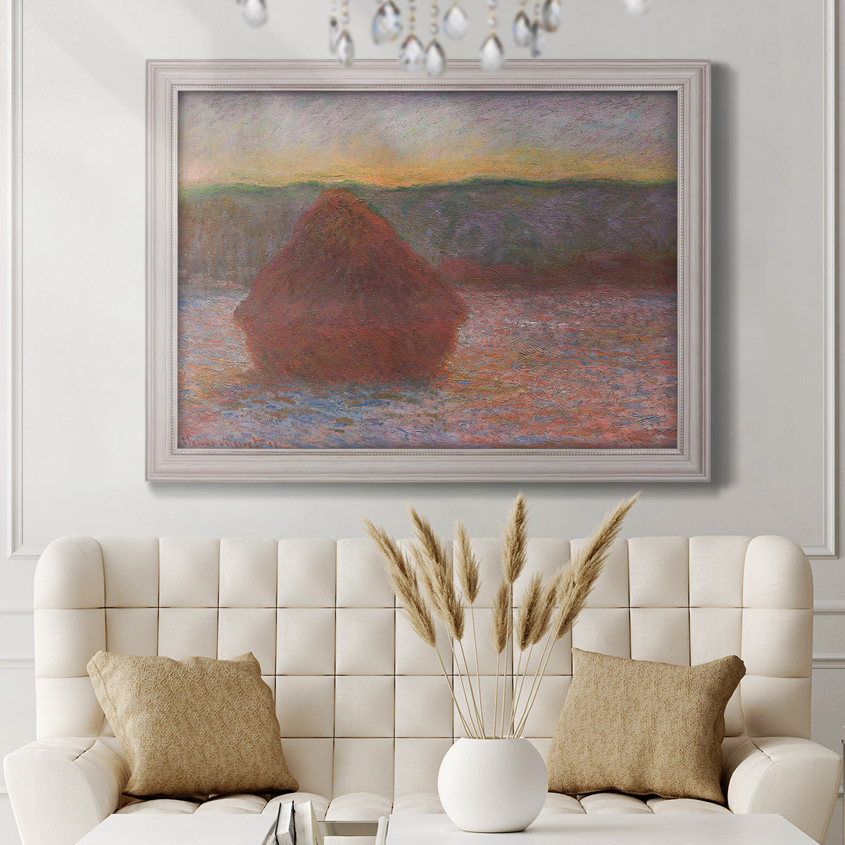 Impressionist haystack sunset scene in winter by Claude Monet in an ornate weathered white frame displayed in a neutral-toned interior setting.