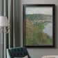 Impressionist landscape view of Vétheuil by Claude Monet in an ornate black frame with gilded inner detail displayed in a neutral interior setting.