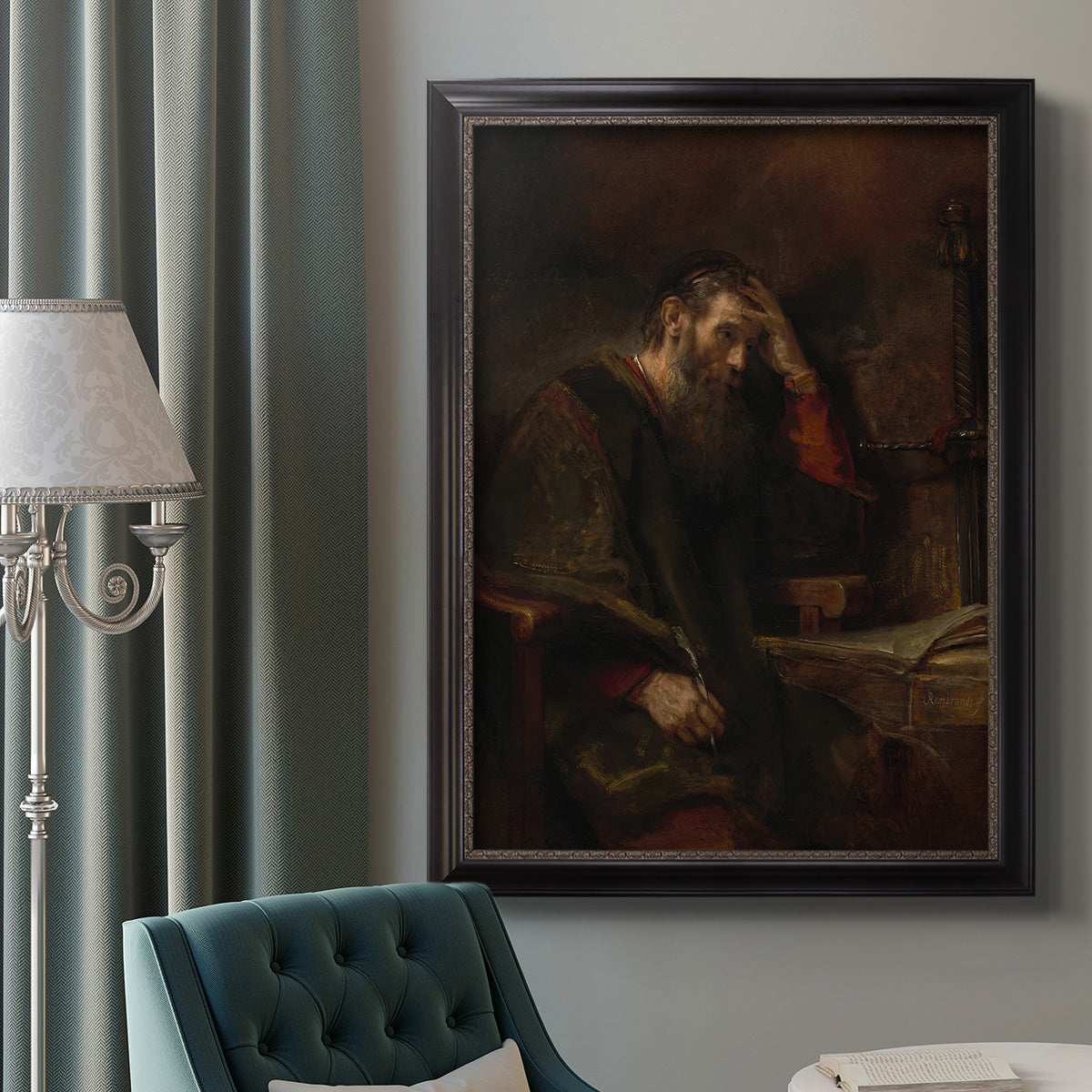 Classical religious portrait of Paul the Apostle by Rembrandt van Rijn in an ornate black frame with gilded inner detail displayed in a neutral interior setting.