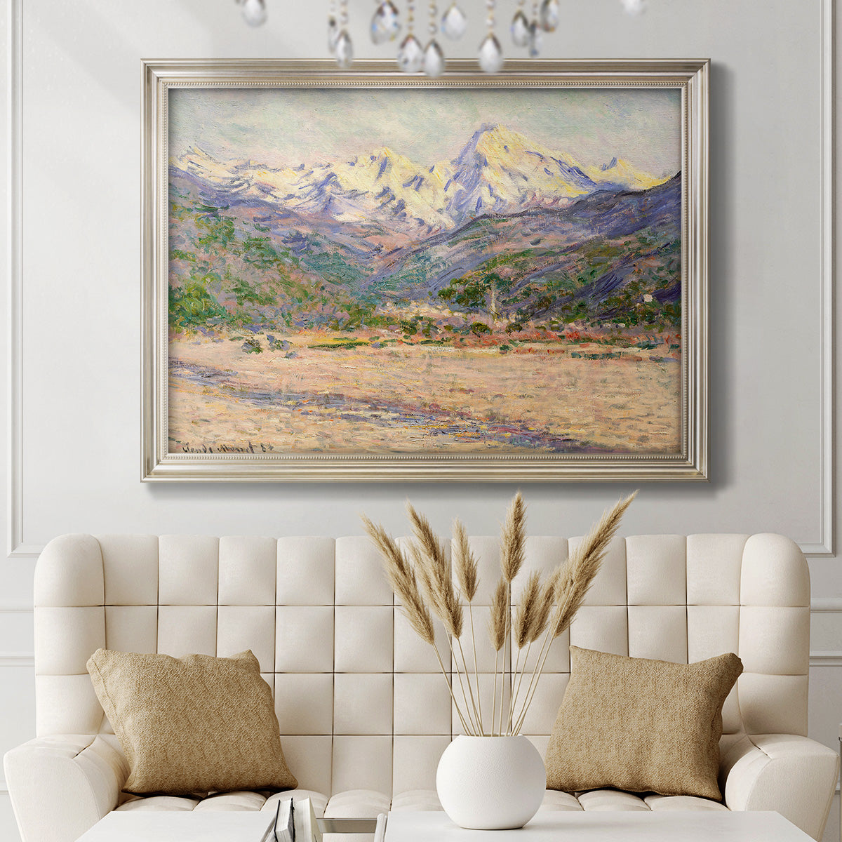 Impressionist valley landscape in southern France by Claude Monet in an ornate champagne frame displayed in a neutral-toned interior setting.