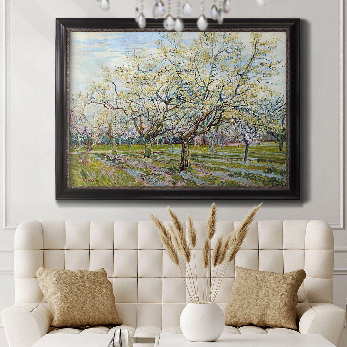 Impressionist white-blossomed orchard landscape by Vincent van Gogh in an ornate black frame with gilded inner detail displayed in a neutral-toned interior setting.