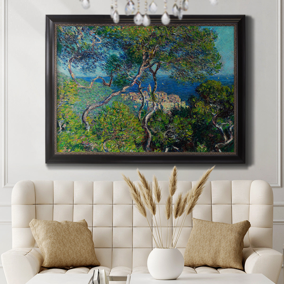 Impressionist Mediterranean coastal landscape by Claude Monet in an ornate black frame with gilded inner detail displayed in a neutral-toned interior setting.