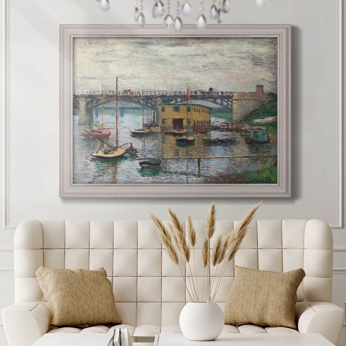 Impressionist river bridge scene on an overcast day by Claude Monet in an ornate weathered white frame displayed in a neutral-toned interior setting.