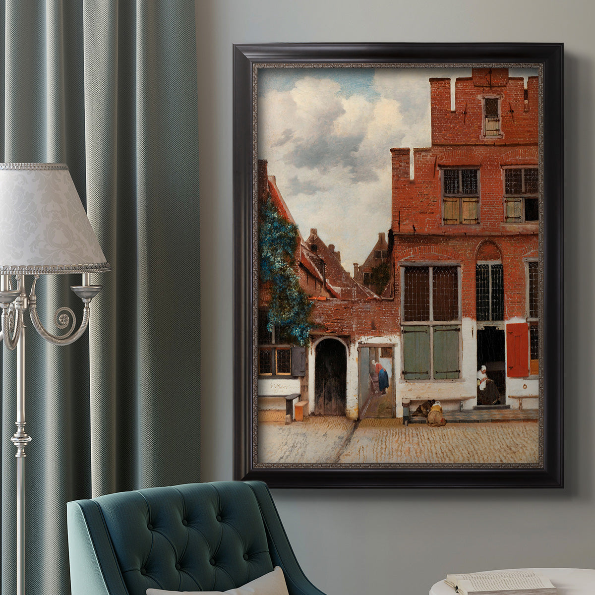 Realist city street scene by Johannes Vermeer in an ornate black frame with gilded inner detail displayed in a neutral interior setting.