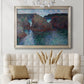 Impressionist rocky seascape by Claude Monet in an ornate champagne frame displayed in a neutral-toned interior setting.
