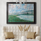 Impressionist river landscape at Vétheuil by Claude Monet in an ornate black frame with gilded inner detail displayed in a neutral-toned interior setting.