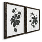 Angled view of a set of two black barnwood framed canvas prints featuring two minimalist botanical prints featuring black leafy vine silhouettes.