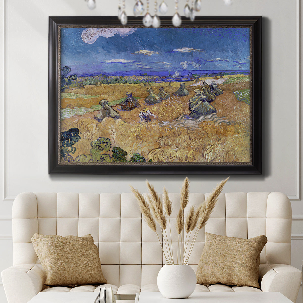 Impressionist wheat harvest scene by Vincent van Gogh in an ornate black frame with gilded inner detail displayed in a neutral-toned interior setting.
