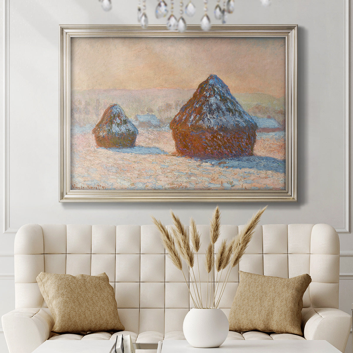 Impressionist winter haystack scene by Claude Monet in an ornate champagne frame displayed in a neutral-toned interior setting.