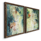 Angled view of a set of two walnut barnwood framed canvas prints featuring two nature-inspired mixed-media abstracts featuring layered blue green cream and charcoal textures.