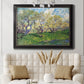 Impressionist spring orchard landscape by Vincent van Gogh in an ornate black frame with gilded inner detail displayed in a neutral-toned interior setting.