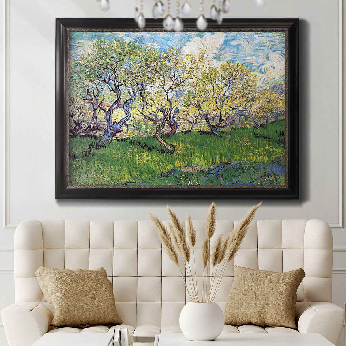 Impressionist spring orchard landscape by Vincent van Gogh in an ornate black frame with gilded inner detail displayed in a neutral-toned interior setting.