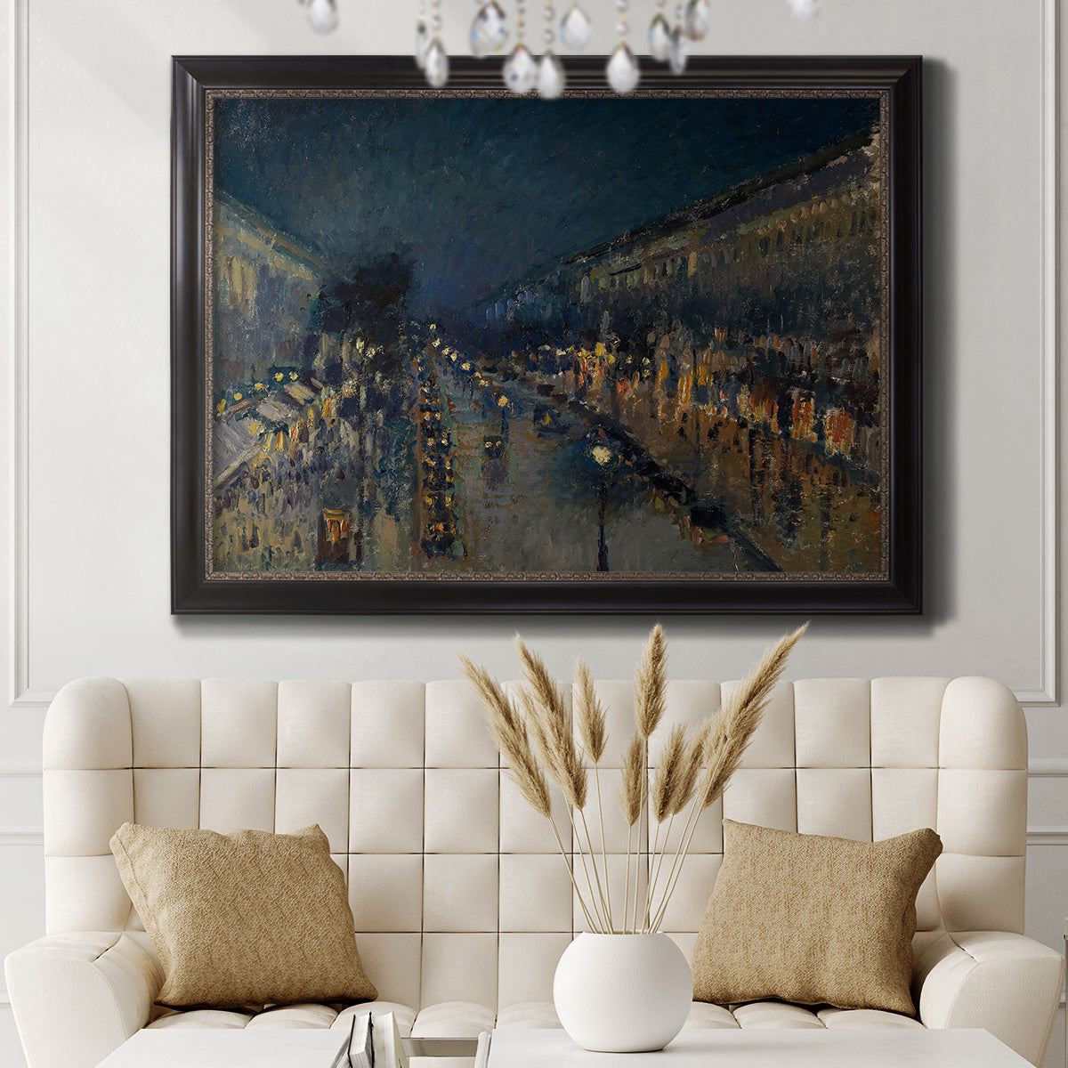 Impressionist nighttime Paris street scene by Camille Pissarro in an ornate black frame with gilded inner detail displayed in a neutral-toned interior setting.