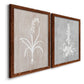 Angled view of a set of two maple barnwood framed canvas prints featuring two rustic minimalist botanical prints featuring white botanical silhouettes on softly weathered neutral backgrounds.