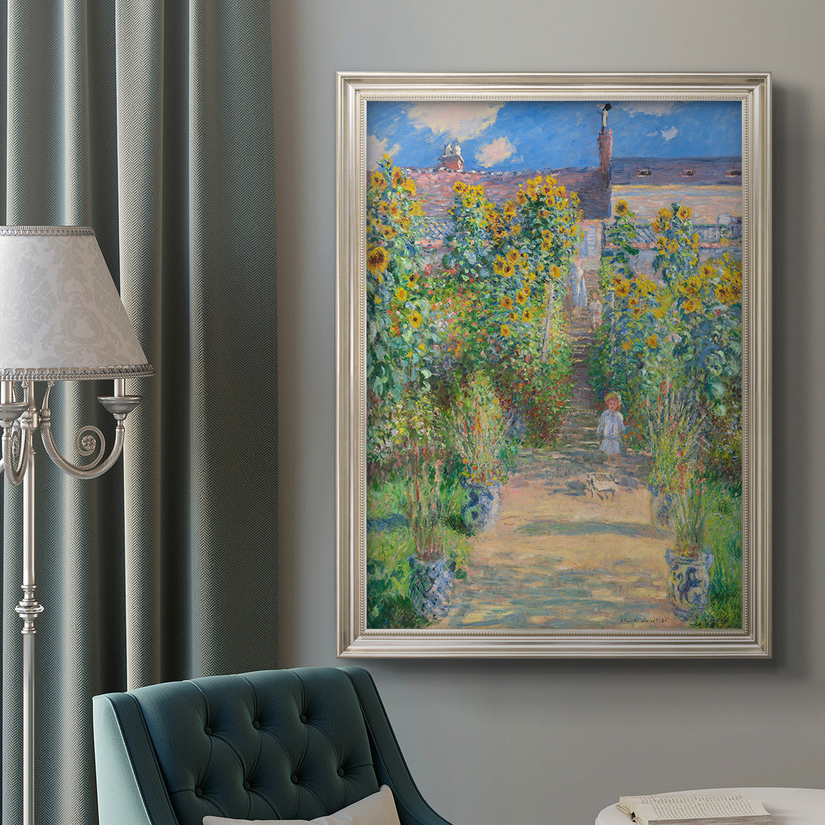 Impressionist garden landscape painting by Claude Monet in an ornate champagne frame displayed in a neutral interior setting.