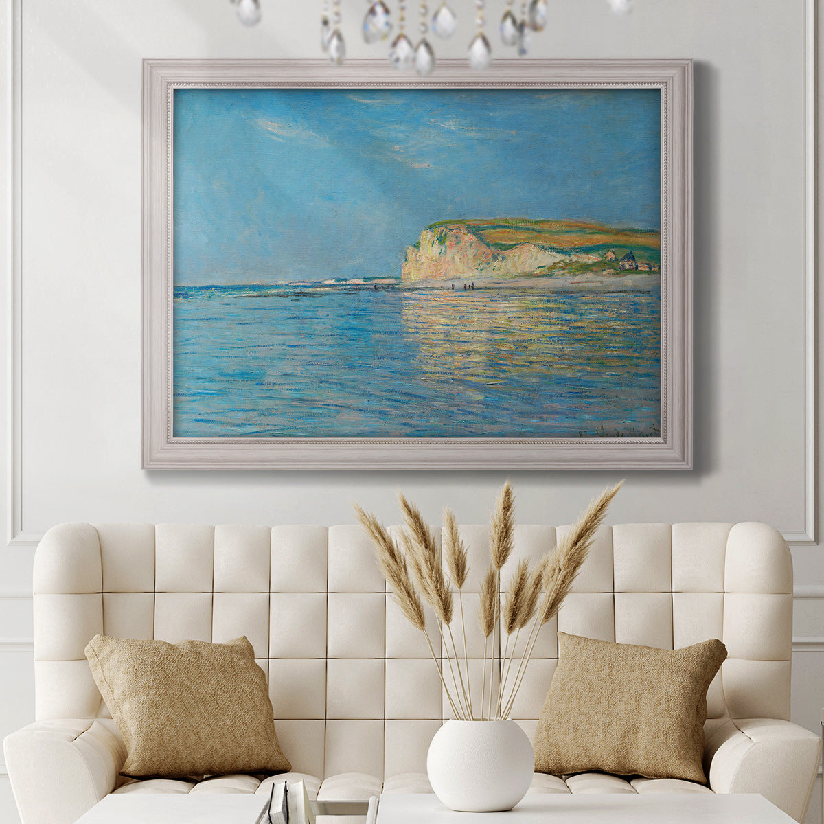 Impressionist coastal low-tide seascape at Pourville by Claude Monet in an ornate weathered white frame displayed in a neutral-toned interior setting.