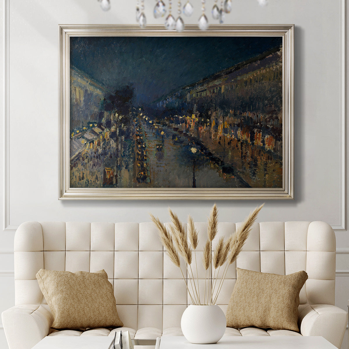Impressionist nighttime Paris street scene by Camille Pissarro in an ornate champagne frame displayed in a neutral-toned interior setting.