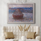 Impressionist single haystack landscape by Claude Monet in an ornate weathered white frame displayed in a neutral-toned interior setting.