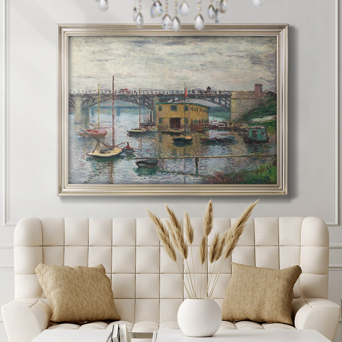 Impressionist river bridge scene on an overcast day by Claude Monet in an ornate champagne frame displayed in a neutral-toned interior setting.