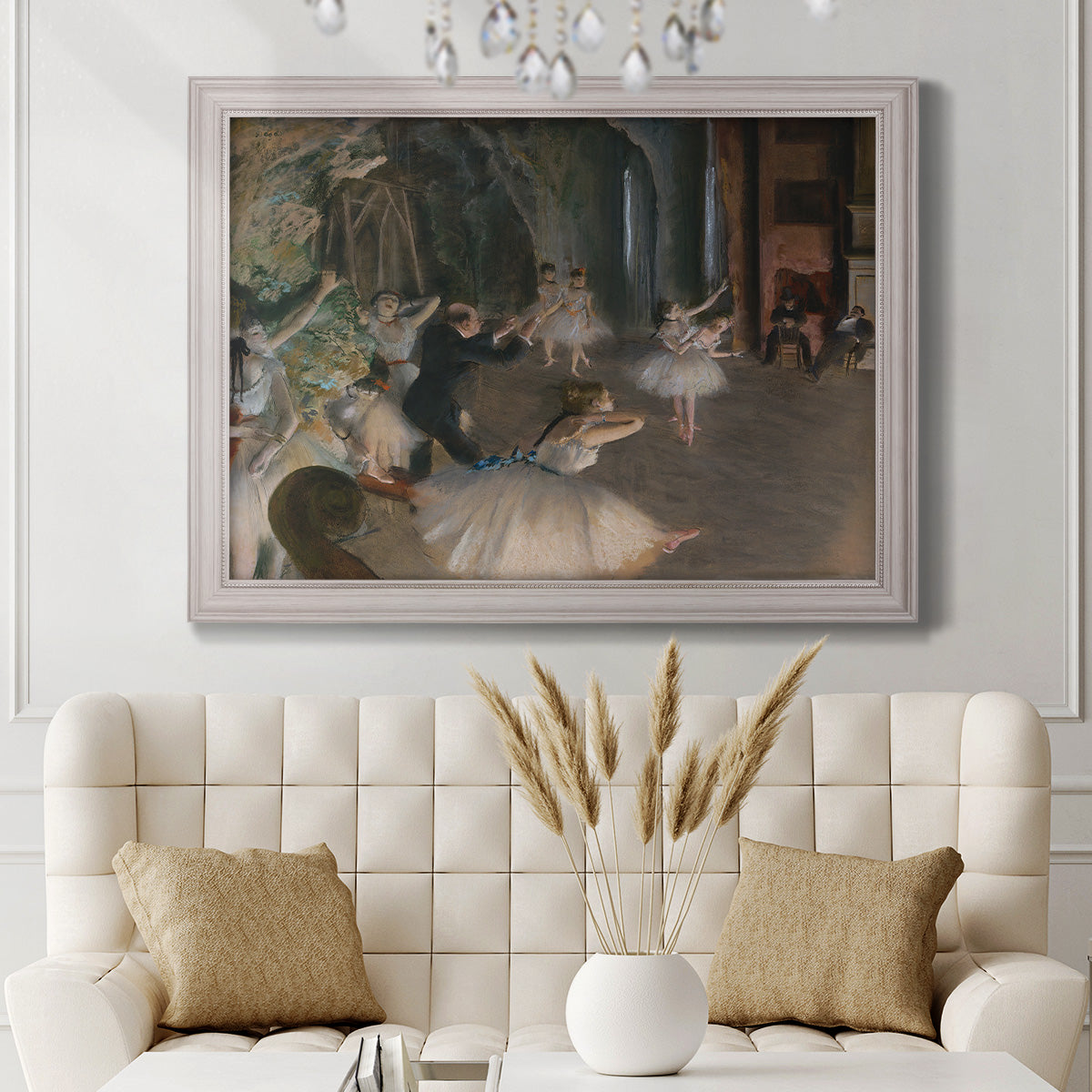 Impressionist backstage ballet scene by Edgar Degas in an ornate weathered white frame displayed in a neutral-toned interior setting.