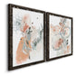 Angled view of a set of two black barnwood framed canvas prints featuring two abstract watercolor botanicals featuring loose blush gray and coral floral gestures.