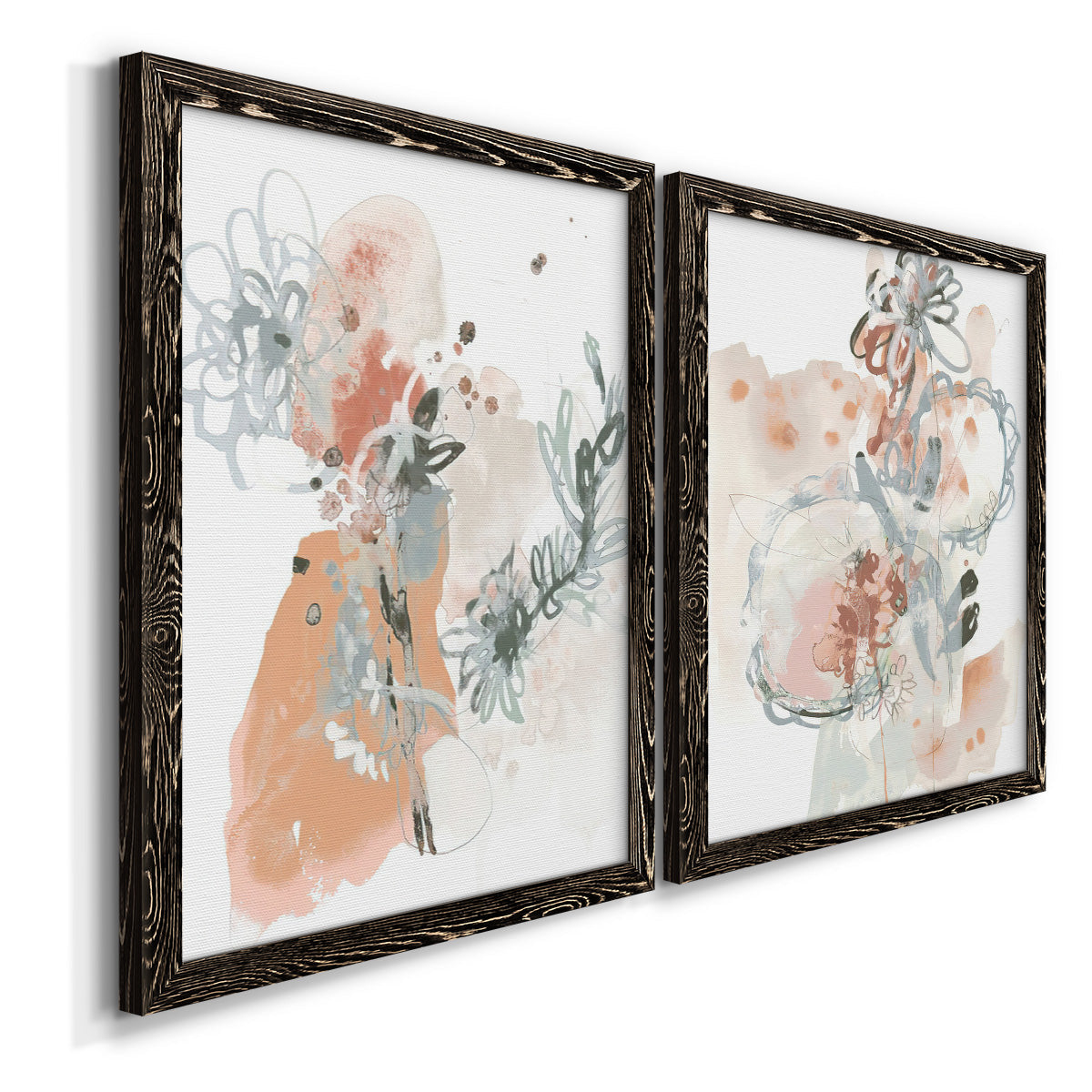 Angled view of a set of two black barnwood framed canvas prints featuring two abstract watercolor botanicals featuring loose blush gray and coral floral gestures.