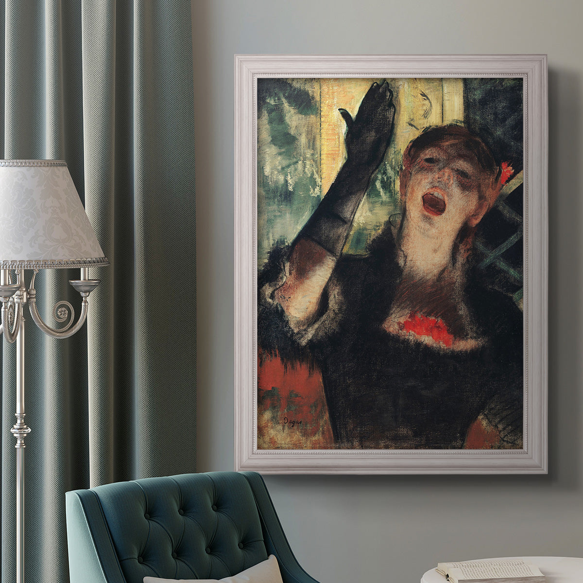 Impressionist portrait of a café singer by Edgar Degas in an ornate weathered white frame displayed in a neutral interior setting.