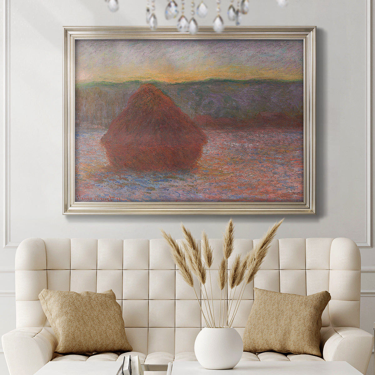 Impressionist haystack sunset scene in winter by Claude Monet in an ornate champagne frame displayed in a neutral-toned interior setting.