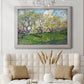 Impressionist spring orchard landscape by Vincent van Gogh in an ornate weathered white frame displayed in a neutral-toned interior setting.