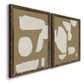 Angled view of a set of two walnut barnwood framed canvas prints featuring two bold minimalist shape abstracts featuring irregular white cutout-like shapes on taupe grounds.