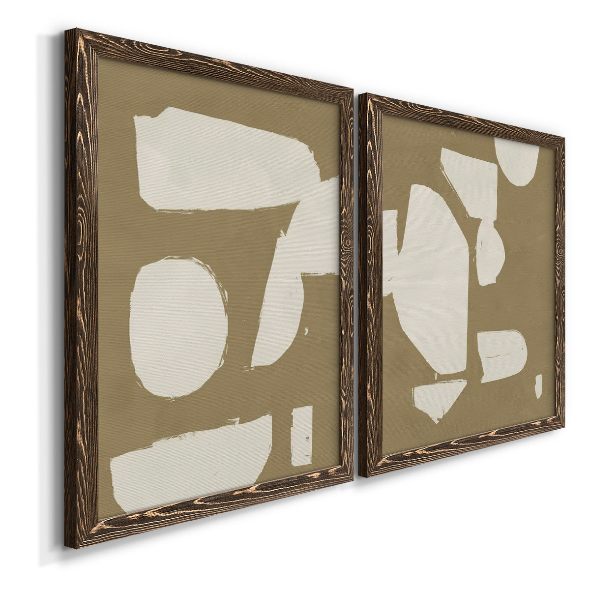 Angled view of a set of two walnut barnwood framed canvas prints featuring two bold minimalist shape abstracts featuring irregular white cutout-like shapes on taupe grounds.