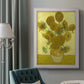 Impressionist sunflower still life painting by Vincent van Gogh in an ornate weathered white frame displayed in a neutral interior setting.
