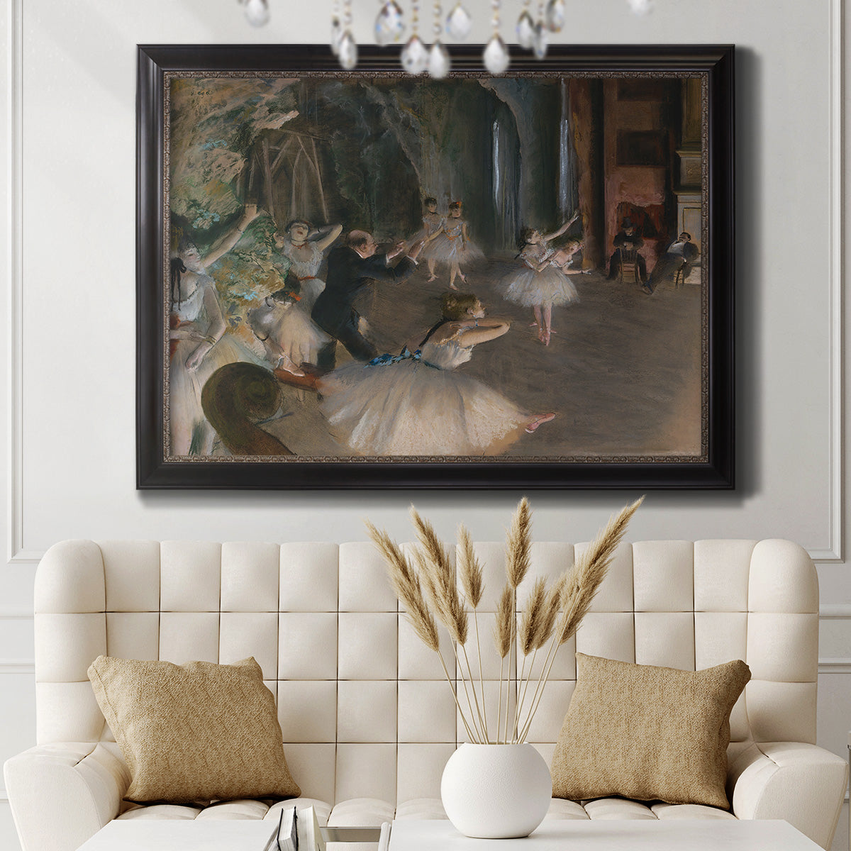 Impressionist backstage ballet scene by Edgar Degas in an ornate black frame with gilded inner detail displayed in a neutral-toned interior setting.